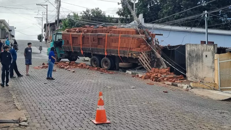 Caminhão carregado de tijolos derruba poste e muro após não conseguir subir morro em Passos (MG)