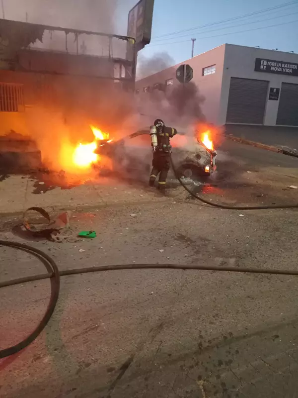 Carro pega fogo e é abandonado por motorista em frente a distribuidora em Cuiabá