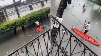 Homem usa stand-up paddle em rua alagada de Fortaleza após chuvas intensas