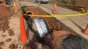 Carro cai em cratera durante temporal em rua em obras em Juiz de Fora