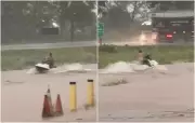 Morador faz manobras com moto aquática em rua alagada após temporal em Campinorte