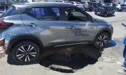 Carro fica preso em cratera após asfalto ceder em Manaus