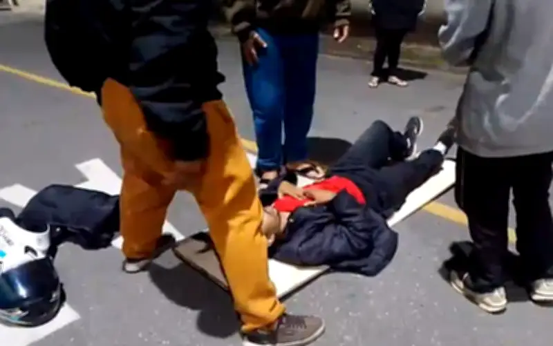 Moradores improvisam maca para socorrer motociclista perto de UPA em MG