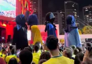 Bonecos gigantes deixam festa com cabeças cobertas após eliminação do Brasil na Copa